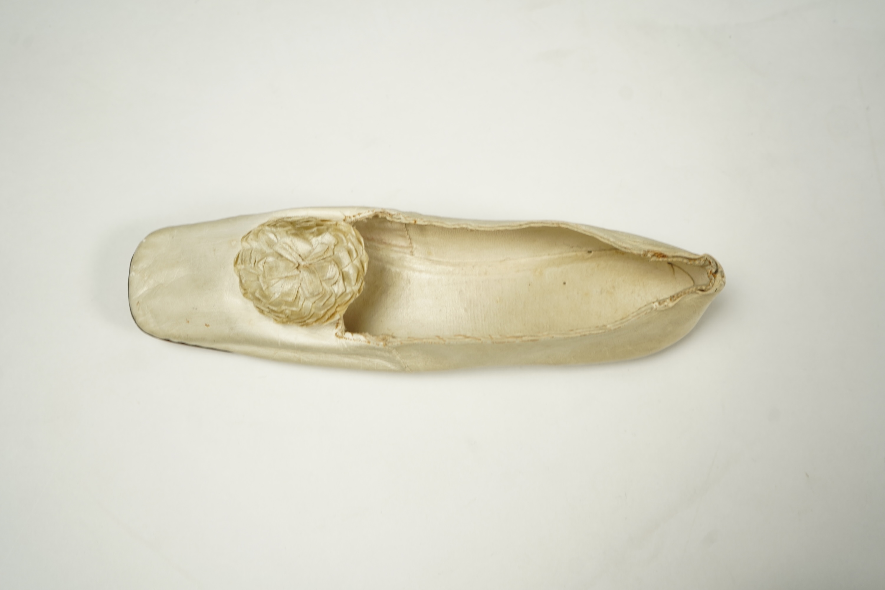 A 19th century hand made cream kid leather ladies ankle boot and four differing cream silk and satin single wedding shoes. All with leather soles. Possibly a traveller's sample range. Boots 24.5cm long (heel to toe). Con
